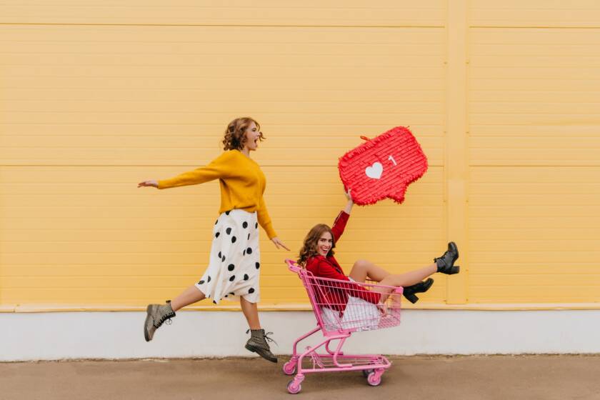 Two best friends fooling around on the street. Full length shot of girls with internet icon